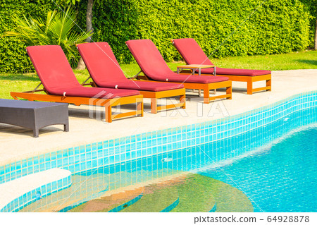 Beautiful empty chair around outdoor swimming pool in hotel resort 64928878