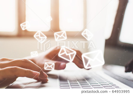 Email marketing and newsletter concept. Hand of man sending message and laptop with e-mail icon 64933995