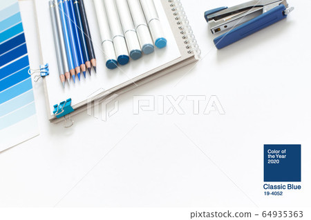Classic Blue. Color of the Year 2020. Top view of workspace with white notebook, color palette, fabric sample and copy space. Flatlay minimalism. Classic Blue. Color of the Year 2020. Top view of workspace with white notebook, color palette, fabric sample and copy space. Flatlay minimalism. 64935363