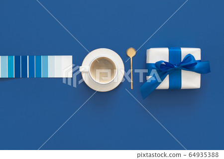 Classic Blue. Color of the Year 2020. Top view of workspace with coffe, gift and glasses and copy space on colored blue background. Flatlay minimalism 64935388