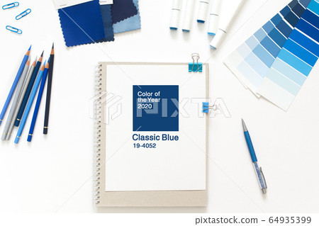 Classic Blue. Color of the Year 2020. Top view of workspace with white notebook, color palette, fabric sample and copy space. Flatlay minimalism. Classic Blue. Color of the Year 2020. Top view of workspace with white notebook, color palette, fabric sample and copy space. Flatlay minimalism. 64935399