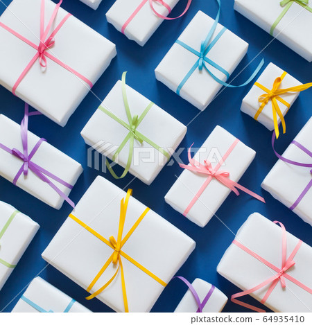Classic Blue. Color of the Year 2020. White gift boxes with colored ribbons on a blue background. 64935410