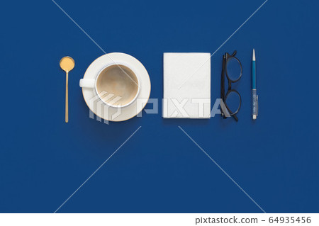 Classic Blue. Color of the Year 2020. Top view of workspace with laptop, succulent, glasses, coffee and copy space on colored blue background. Flatlay minimalism Classic Blue. Color of the Year 2020. Top view of workspace with laptop, succulent, glasses, coffee and copy space on colored blue background. Flatlay minimalism 64935456