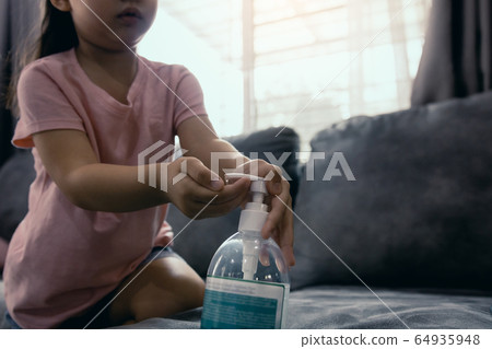 Asian girl kid using wash hand sanitizer alcohol 64935948