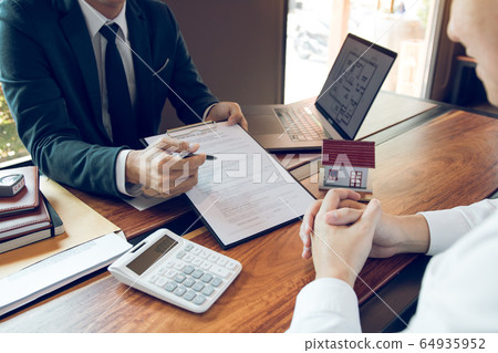 Agents are using pens pointing to contracts and Agents are using pens pointing to contracts and 64935952
