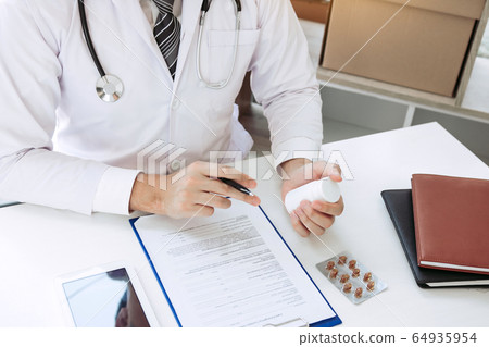 Confident doctor man holding a pill bottle and Confident doctor man holding a pill bottle and 64935954