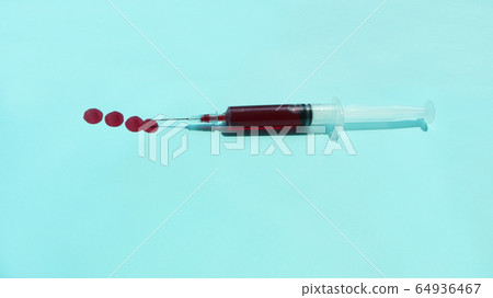 在藍色背景的紅色血液注射器 在藍色背景的紅色血液注射器 64936467