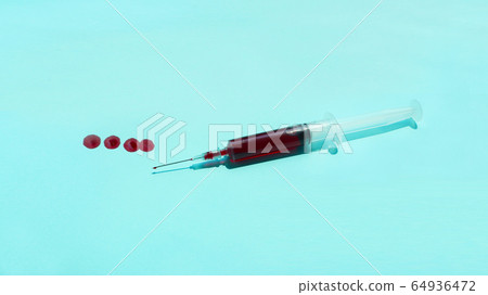 Syringe with red blood over blue background Syringe with red blood over blue background 64936472