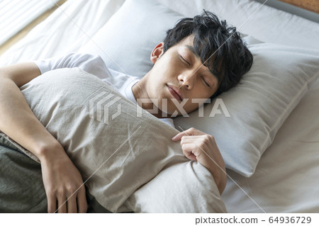 Young man sleeping in bed Young man sleeping in bed 64936729
