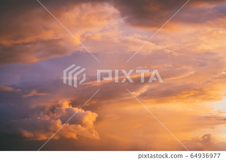 Evening sunset sky with bright rays of the sun and beautiful colorful clouds 64936977