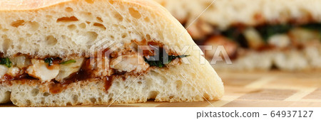 Cut chiken sandwich with ketchup against kitchen background Cut chiken sandwich with ketchup against kitchen background 64937127