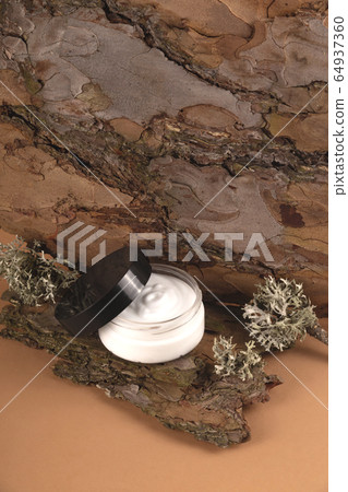 Cream for the face on the bark of a tree. Natural care concept. 64937360