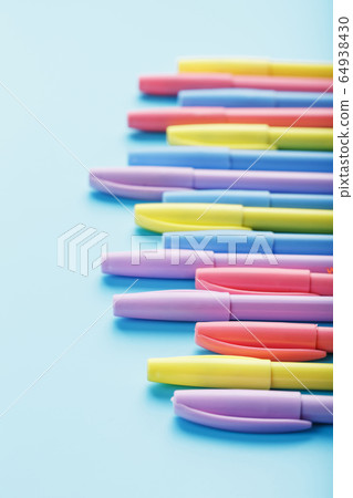 Multi-colored pens on a blue background with free Multi-colored pens on a blue background with free 64938430
