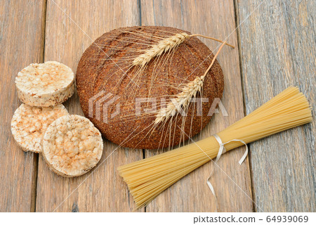 Cereal products on old wooden table. 64939069