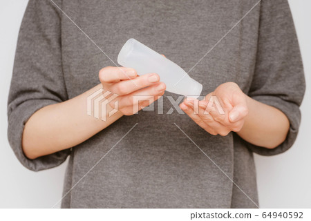 Woman disinfecting her hands using sanitaser gel. Woman disinfecting her hands using sanitaser gel. 64940592