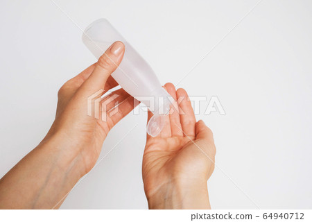 Woman disinfecting her hands using sanitaser gel. Woman disinfecting her hands using sanitaser gel. 64940712