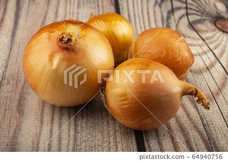 Juicy ripe onions on a wooden background. Close Juicy ripe onions on a wooden background. Close 64940756