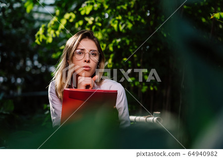 Young female agricultural engineer working in greenhouse. Young female agricultural engineer working in greenhouse. 64940982