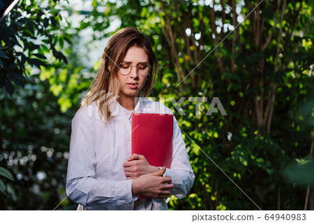 Young female agricultural engineer working in greenhouse. Young female agricultural engineer working in greenhouse. 64940983