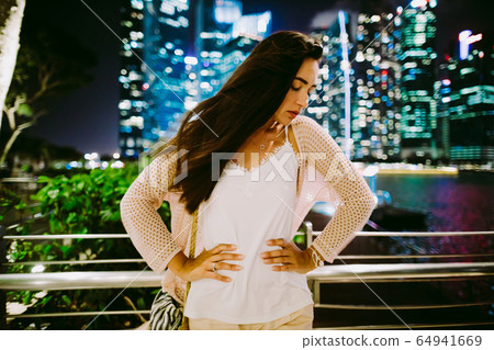confused woman portrait standing outdoors at night confused woman portrait standing outdoors at night 64941669