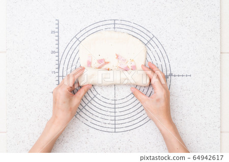 Making bread at home Process of making onion bacon bread 4-Spread dough, sprinkle bacon and roll dough Making bread at home Process of making onion bacon bread 4-Spread dough, sprinkle bacon and roll dough 64942617