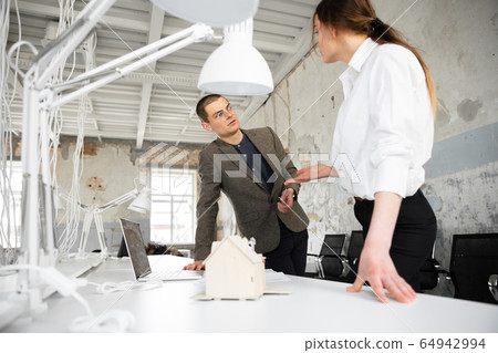 Female estate agent showing new home to a young man after a discussion on house plans, moving, new home concept Female estate agent showing new home to a young man after a discussion on house plans, moving, new home concept 64942994