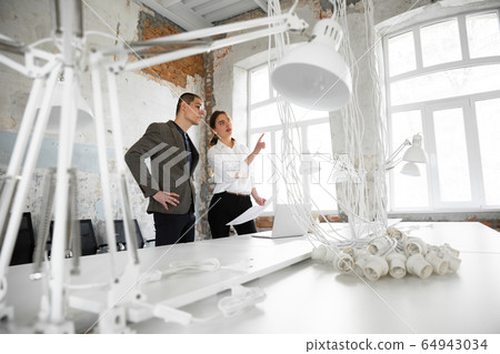 Female estate agent showing new home to a young man after a discussion on house plans, moving, new home concept 64943034