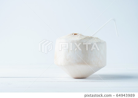 Tropical drinking coconut on white wood background. 64943989