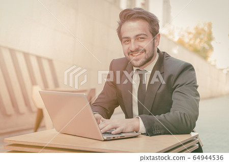 Smiling businessman laptop table for concept design. Business portrait outdoor. Wireless communication. Business without office concept. Business technology. Business career concept Smiling businessman laptop table for concept design. Business portrait outdoor. Wireless communication. Business without office concept. Business technology. Business career concept 64944536