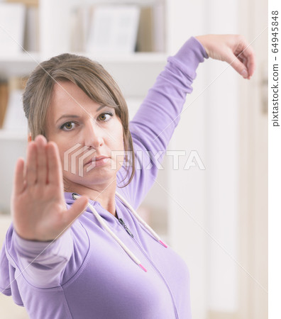 Woman doing qi gong tai chi exercise 64945848