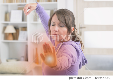 Woman doing qi gong tai chi exercise 64945849