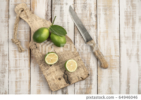 sliced limes on a wooden cutting board on a table sliced limes on a wooden cutting board on a table 64946046