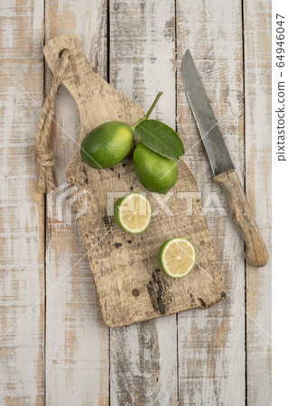 sliced limes on a wooden cutting board on a table sliced limes on a wooden cutting board on a table 64946047