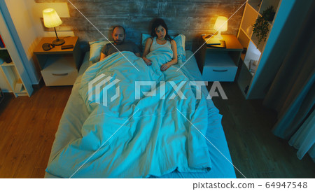 Young wife with her husband under the sheet 64947548