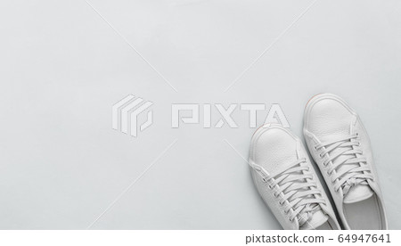 White sneakers on blue, copy space, top view 64947641