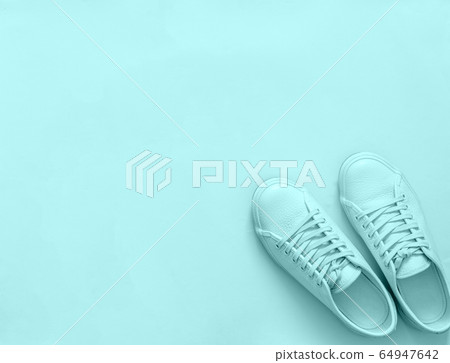 Blue sneakers on blue background, copy space Blue sneakers on blue background, copy space 64947642