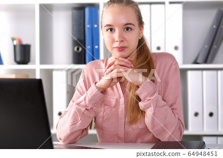 Girl sitting at workspace office in front laptop 64948451