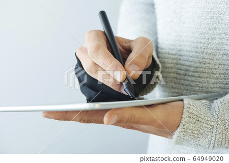 man wearing a two finger glove using a tablet 64949020