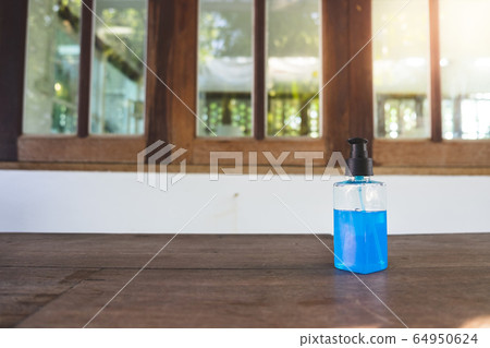 Close-up of 70% Blue Ethyl alcohol gel in the plastic bottle on the wooden desk for coronavirus protection Close-up of 70% Blue Ethyl alcohol gel in the plastic bottle on the wooden desk for coronavirus protection 64950624