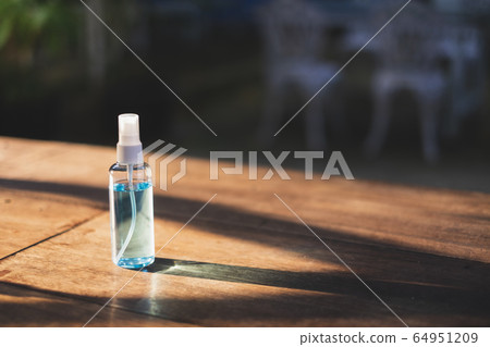 Close-up of 70% Blue Ethyl alcohol spray bottle on the wooden desk. Use for Coronavirus Protection Close-up of 70% Blue Ethyl alcohol spray bottle on the wooden desk. Use for Coronavirus Protection 64951209