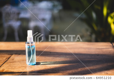 Close-up of 70% Blue Ethyl alcohol in the spray bottle for coronavirus protection on the wooden desk Close-up of 70% Blue Ethyl alcohol in the spray bottle for coronavirus protection on the wooden desk 64951210