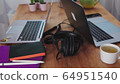 home office during the coronavirus pandemic. two laptops, a tablet, pens, headphones are on the kitchen table. work from home. self-isolation 64951540