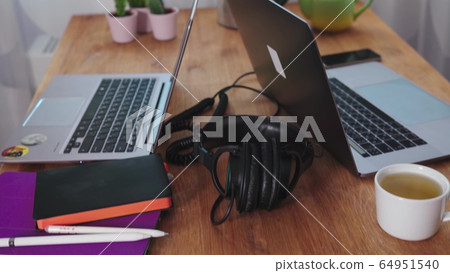 home office during the coronavirus pandemic. two laptops, a tablet, pens, headphones are on the kitchen table. work from home. self-isolation home office during the coronavirus pandemic. two laptops, a tablet, pens, headphones are on the kitchen table. work from home. self-isolation 64951540