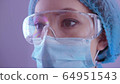 Asian woman doctor in a protective mask and coat, in safety glasses on a background of blue wall in a hospital ward.. 2019 Novel Coronavirus (2019-nCoV), COVID-19 64951543