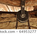 A fragment of a load-lifting mechanism suspended from the ceiling. 64953277