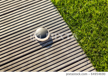 Round black outdoor lighting on a light brown jetty. Round black outdoor lighting on a light brown jetty. 64954690