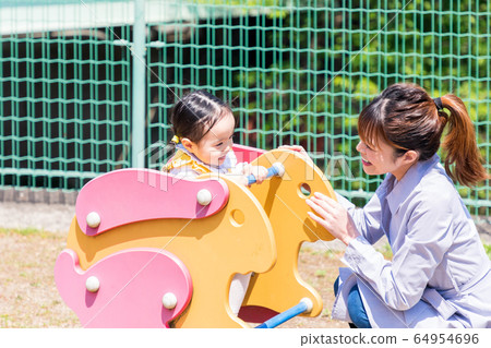 有孩子,媽媽和可愛的女孩的家庭在公園玩 有孩子,媽媽和可愛的女孩的家庭在公園玩 64954696