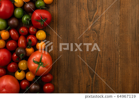 Colorful tomatoes placed on a wooden background Colorful tomatoes placed on a wooden background 64967119