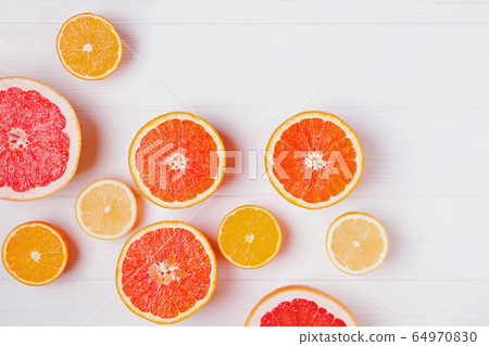 Halves of fresh orange and grapefruit citrus fruits on white wooden background Halves of fresh orange and grapefruit citrus fruits on white wooden background 64970830