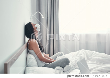 Negative delighted brunette girl sitting on her bed 64971003